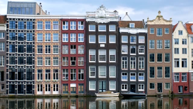 houses-and-boat-on-Amsterdam-canal-Damrak-with-reflection.-Ams