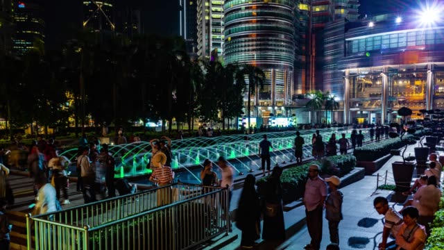 KUALA-LUMPUR,-Malasia---15-de-mayo-de-2018:-Fuente-en-la-noche-con-la-gente-cerca-de-Torre-gemela-de-Petronas-4-K