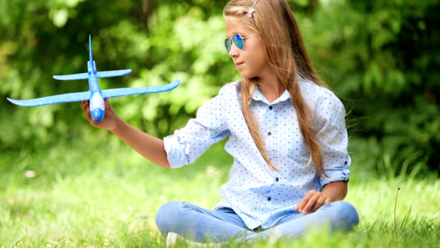 Nine-year-old-girl-playing-with-toy-airplane