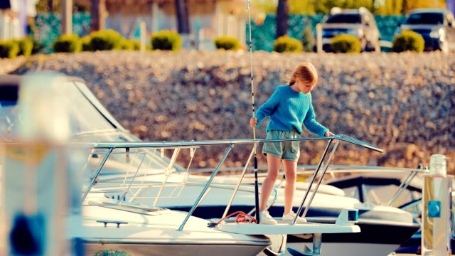 Kleine-Mädchen-ein-Kind-auf-einer-Yacht-oder-ein-Boot-besitzt-eine-Angelrute-und-befasst-sich-mit-dem-Fisch