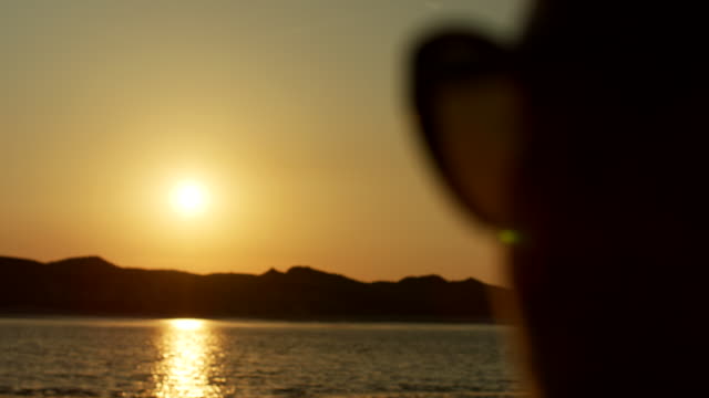 Silhouette-Of-Woman-Watching-Golden-Sunset-At-Beach