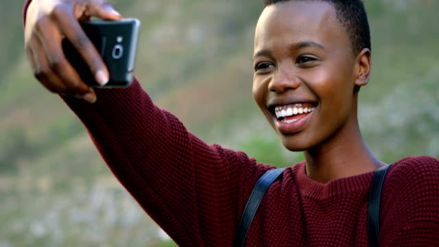 Mujer-tomando-selfie-con-teléfono-móvil-en-el-campo-4k