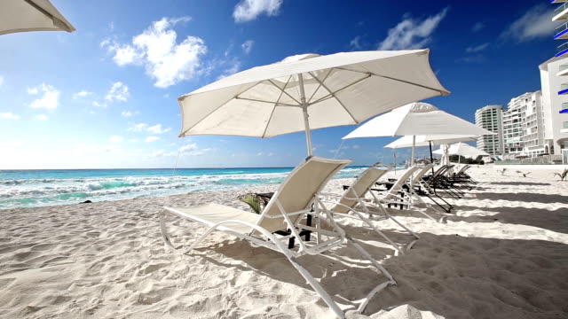 Playa-de-puesta-del-sol-caribeño-con-sombrillas-y-camas