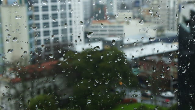 Caídas-de-gotas-de-lluvia-en-una-ventana-con-vistas-al-paisaje-urbano