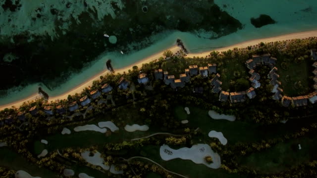 Tropical-island-with-houses-on-the-coast,-aerial-view