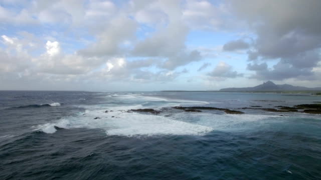 Luftaufnahme-der-Wasserlinie-der-Meere,-die-nicht-gegen-blauen-Himmel-mit-Wolken,-Insel-Mauritius-mischen