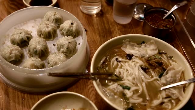 Pan-down-upclose-shot-of-Korean-dumplings-and-noodle-dish