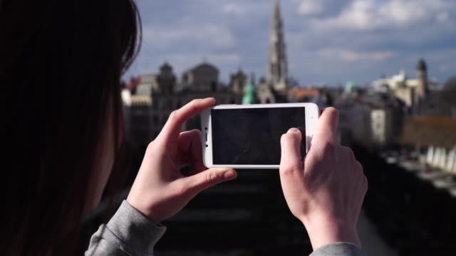 Frau-Tourist-nimmt-Pictureson-auf-Smartphone-in-Brüssel-Belgien