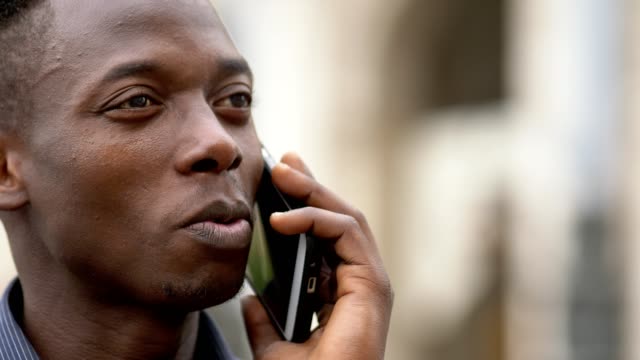 Tranquilo-americano-africano-joven-hablando-por-teléfono-cierre-para-arriba