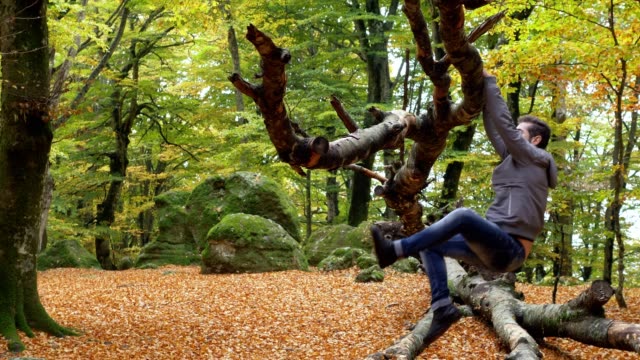 Mann-läuft-allein-im-Wald-und-auf-dem-Ast-eines-Baumes-hängt.-Sport,-Stärke,