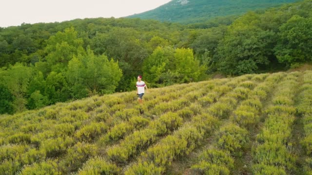 young-man-in-casual-walking-on-a-mountain-field-in-the-evening-during-summer-season