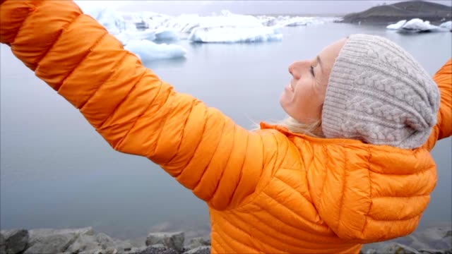 Slow-Motion-Mädchen-ausgestreckten-Armen-an-die-Gletscherlagune-Islands