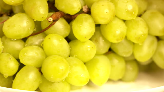 Bunch-of-white-grapes-turning-around.-Wet-green-grape-with-water-drops-close-up