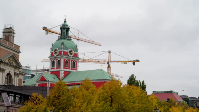Two-cranes-on-the-back-of-the-clock-tower-in-Stockholm-Sweden