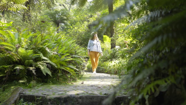 Young-lady-walking-along-park-path