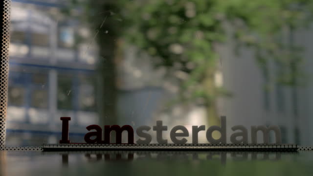 Window-of-moving-tram-with-I-amsterdam-slogan