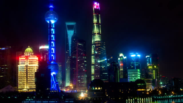 Night-time-lapse-of-the-Huangpu-river,-the-Pudong-financial-business-district,-and-the-Bund,-Shanghai-skyline,-urban-China