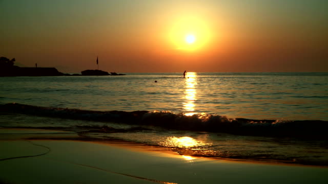 Silhouette-eines-Surfers,-schwimmt-über-den-Weg-von-der-Sonne,-das-Meer-bei-Sonnenuntergang.