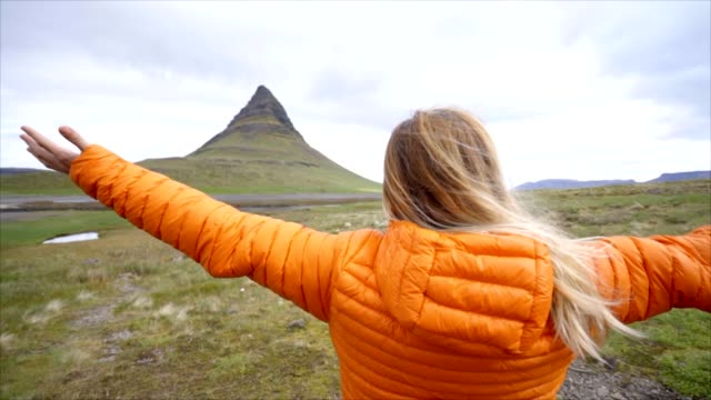 Junge-Frau-in-Island-ausgestreckten-für-Freiheit-Frühling-bedecktem-Himmel-am-berühmten-Berg-Kirkjufell