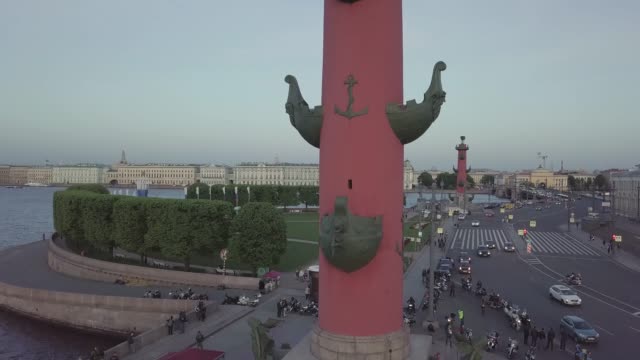 Red-Rostral-Columns-and-Old-Saint-Petersburg-Stock-Exchange-on-Spit-Strelka-of-Vasilievsky-Island.-Neva-river.-Day-traffic.-summer-day,-dramatic-mood.-FullHD-drone-aerial-footage.-Slow-Drift.-panorama