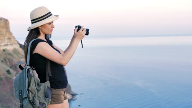 Attraktive-junge-Frau-Fotograf-in-Hut-nehmen-Foto-oder-Video-mit-professioneller-Kamera
