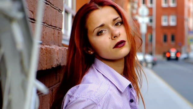 Porträt-von-sexy-Frau-mit-langen-roten-Haaren,-in-der-Stadt.