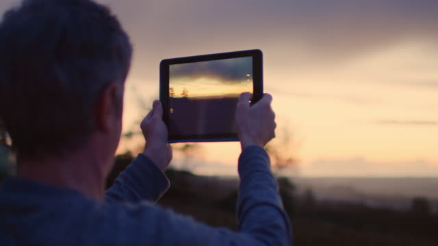 Mann-fotografieren-schönen-Sonnenuntergang-durch-Digital-Tablette-4K