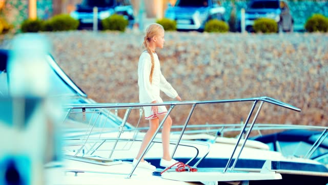 Beautiful-little-girl-on-the-deck-of-a-yacht-looks-somewhere-and-thinks-about-something