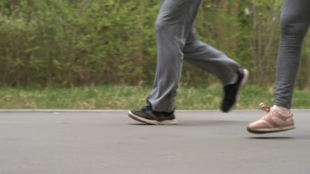 Unrecognizable-People-Jogging-along-Pavement