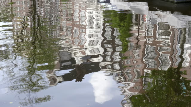 eine-abstrakte-Schuss-von-Gebäuden-reflektiert-auf-dem-Wasser-von-einem-Amsterdamer-Kanal