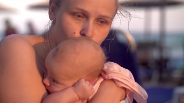 Mum-with-baby-on-the-beach-at-sunset