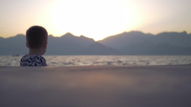 Einsames-Kind-am-Meer-bei-Sonnenuntergang