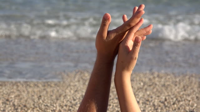 Gentle-touch,-lovers-hands-playing,-finger-touch,-close-up,-beach,-sea-waving