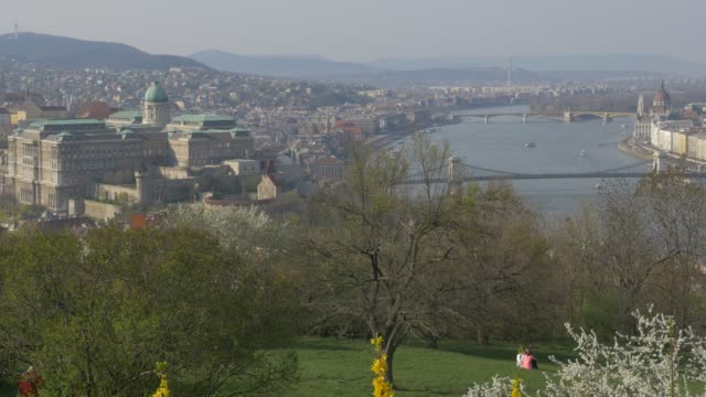 Royal-Castle-Parliament-building-and-Danube-river-scene-from-Citadela-hill-sight-4K-2160p-UltraHD--tilting-footage----Buda-side-of-Hungarian-capital-by-the-day--4K-3840X2160-UHD-video