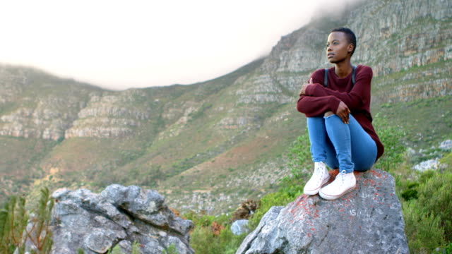 Woman-sitting-on-a-rock-at-countryside-4k
