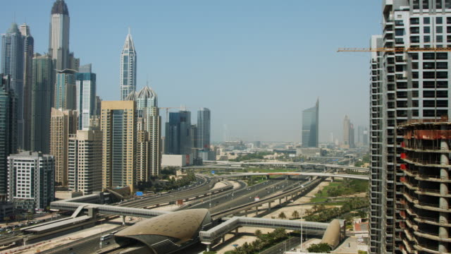 Pan-shot-of-towers-en-una-ciudad,-Dubai,-Emiratos-Árabes-Unidos