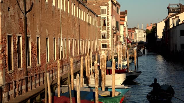 Bote-de-remos-de-hombre-en-Canal-de-Venecia-al-amanecer-o-al-atardecer