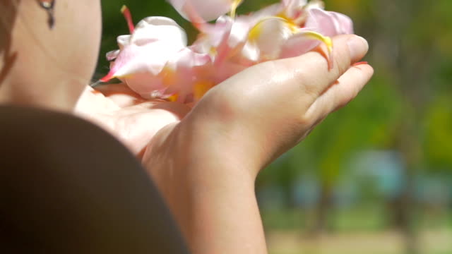 Frau-bläst-Blütenblätter-aus-den-Händen