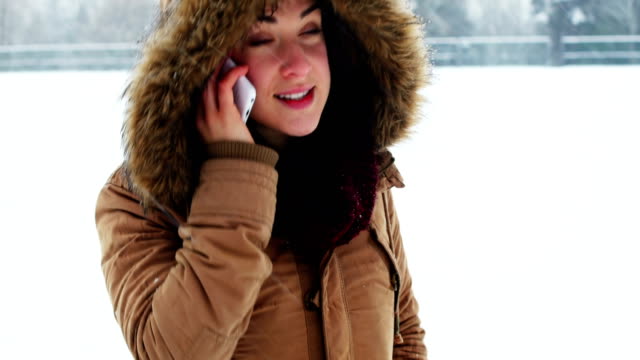 Smiling-woman-in-fur-jacket-talking-on-mobile-phone