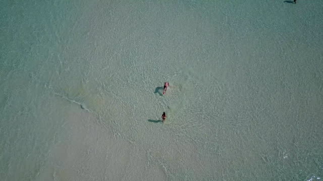 v03815-fliegenden-Drohne-Luftaufnahme-der-Malediven-weißen-Sandstrand-am-sonnigen-tropischen-Inselparadies-mit-Aqua-blau-Himmel-Meer-Wasser-Ozean-4k-2-Personen-junges-Paar-Mann-Frau-Ball-Spaß-zusammen-zu-spielen