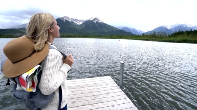 Frau-stehend-auf-schönen-Bergsee,-Blick-auf-die-atemberaubende-Landschaft-der-kanadischen-rockies