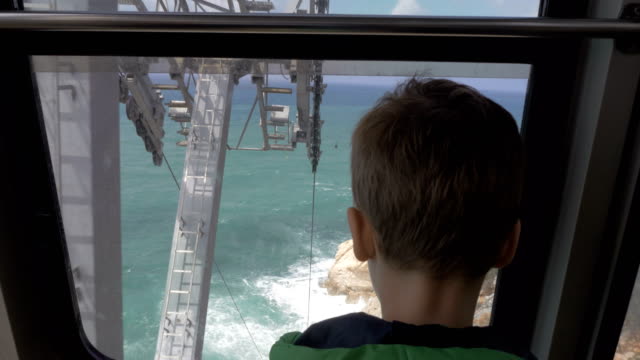 Boy-looking-at-sea-from-moving-funicular-in-Rosh-Hanikra