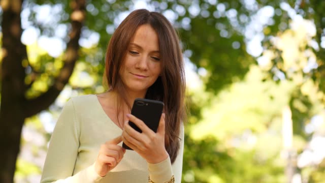 Romantic-brunette-girl-chatting-in-smartphone