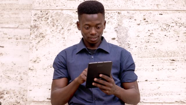Attraktive-Afrikanische-amerikanische-Mann-mit-digitalen-Tablet-outdoor