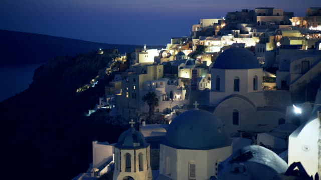 weiten-Blick-über-drei-blauen-Kuppeln-in-der-Nacht-in-Oia,-Santorin