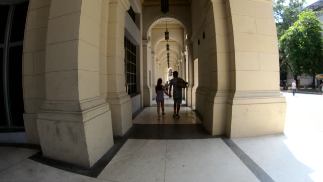 Pareja-caminando-de-manos-de-explotación-con-hermosa-arquitectura-en-la-Habana-Vieja-Cuba