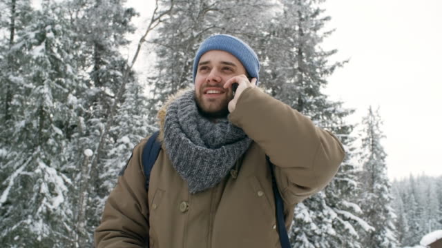 Man-Talking-on-Phone-Outdoors-at-Snowy-Day