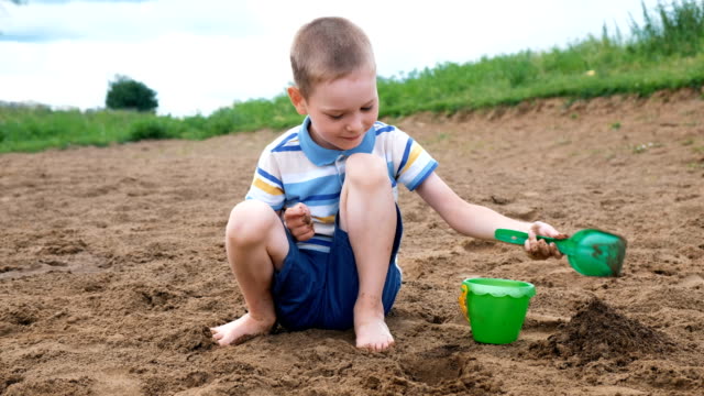 Kleiner-Junge-spielt-mit-einer-Schaufel-eine-Grube-zu-graben.-Kinder-spielen-am-Strand