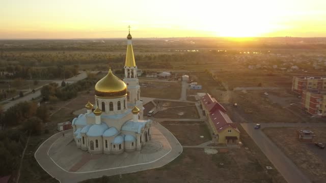 aerial-gorgeous-gold-and-white-church-during-the-sunset-against-the-amazing-skyline