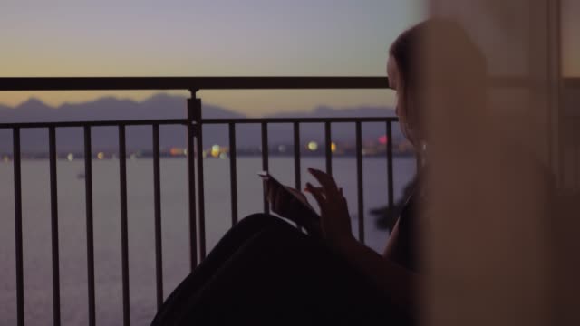 Mujer-joven-en-un-balcón-contra-paisajes-de-mar